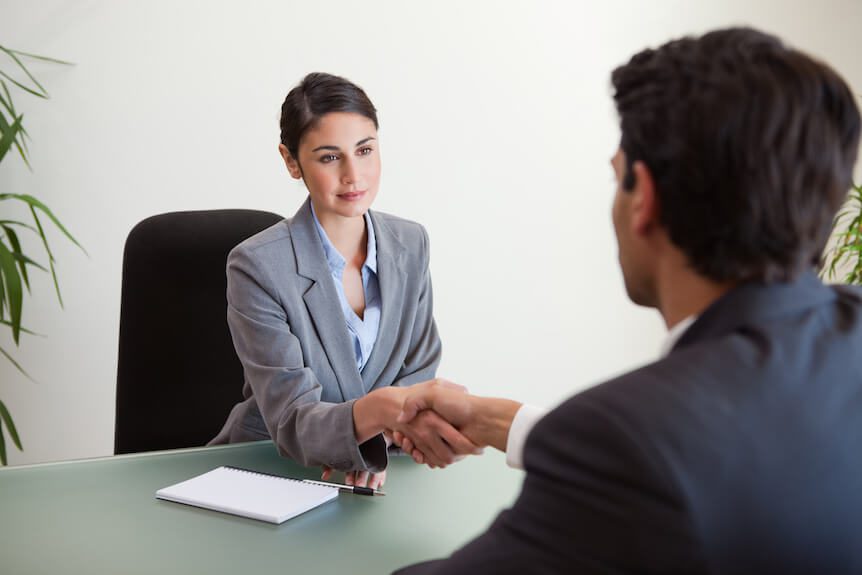 Two business people shaking hands to show the hire process.