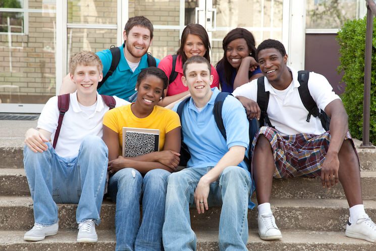 Summer melt and management of new college students sitting on steps on campus.