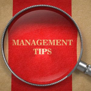 Management Tips . Magnifying Glass on Old Paper with Red Vertical Line.